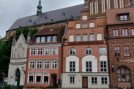 Dieses Bild zeigt den Alten Markt in der Hansestadt Stralsund, Mecklenburg-Vorpommern. Der Platz ist von historischen Gebäuden umgeben, darunter das Nicolai Cafe.