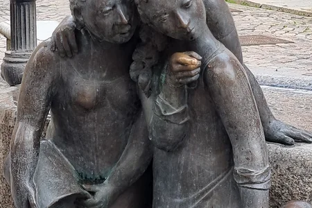 Dies ist eine detaillierte Aufnahme der Bronzeskulpturen des Mägdebrunnens in Stralsund, der im Volksmund auch als „Die geschwätzigen Weiber“ bekannt ist.